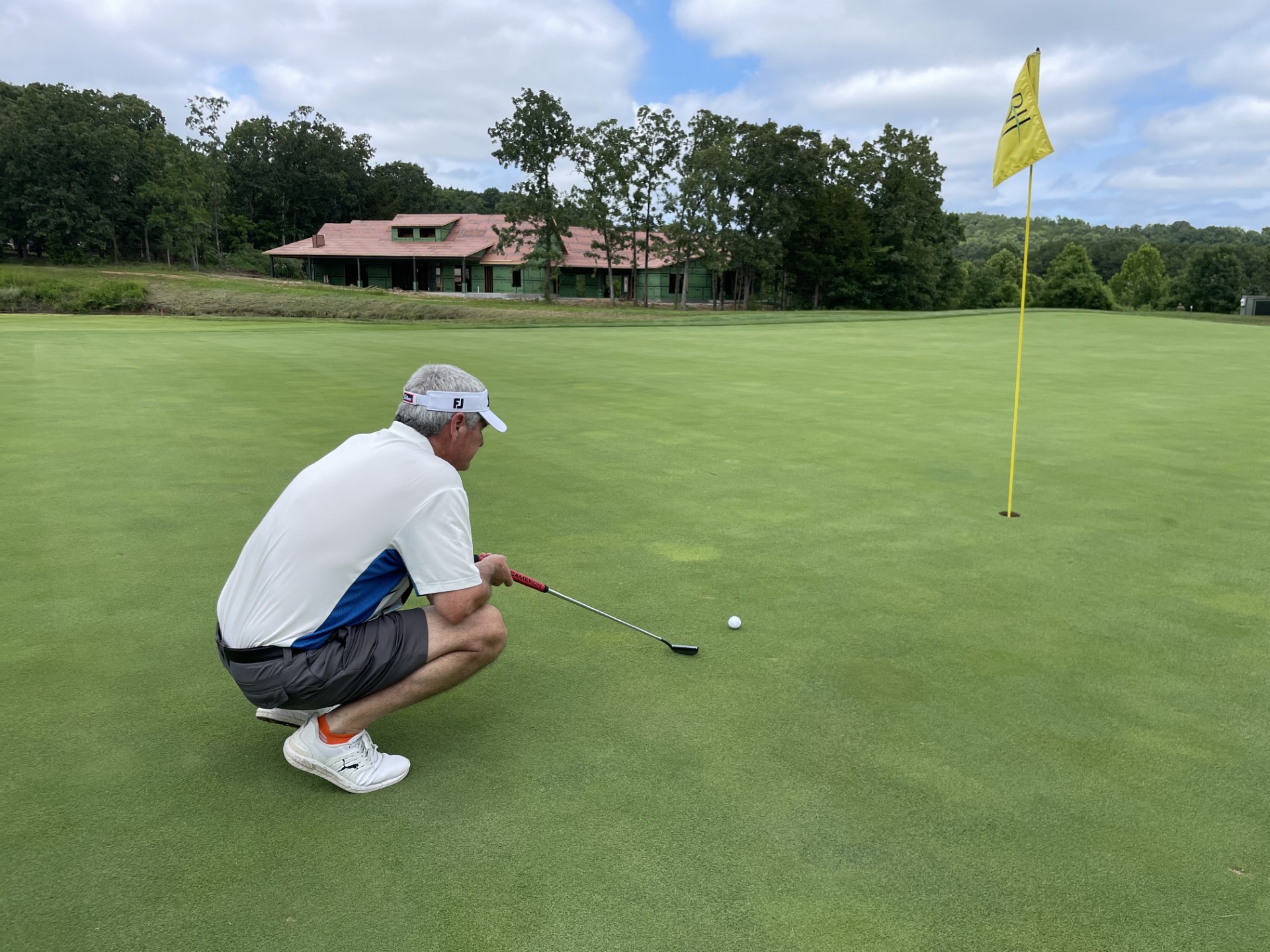 Greg Richard finishing a tee shot on an elevated hole